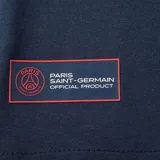 Remera azul marino de algodón con cuello redondo y manga corta. Estampado frontal con el escudo del Paris Saint-Germain y la palabra "Paris" en rojo.