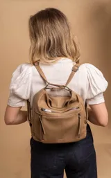 Cartera mochila versátil de cuero sintético con textura granulada, color negro. Cuenta con múltiples bolsillos frontales con cierre, correas ajustables que permiten su uso tanto como cartera de hombro o como mochila, y herrajes metálicos.