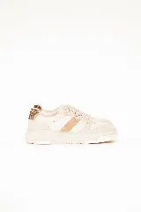 Championes de diseño moderno en tonos beige y blanco, con franja lateral de color tostado y detalle de estampado animal print en el talón. Tienen suela tipo plataforma y cierre con cordones.