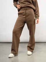 Pantalón de jogging recto de felpa, color marrón, con cintura elástica ajustable mediante cordón y logo de la marca bordado en la parte superior.