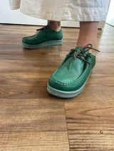 Zapato acordonado color verde con suela de goma.