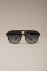 Lentes de sol estilo aviador con montura gruesa de acetato con patrón carey en tonos verde oliva y negro. Lentes oscuros con degradado gris.