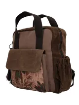 Mochila marrón de diseño patchwork y estilo bohemio, confeccionada en material textil. Cuenta con compartimento principal con cierre, bolsillo frontal con solapa decorada con tapicería estampada, bolsillos laterales, asas superiores fijas y correas ajustables. Incluye un llavero colgante lateral con borla y cuentas decorativas.