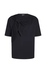 Remera de algodón negra, de corte recto y holgado, con escote redondo, mangas cortas y detalle frontal de banda retorcida con lazo y drapeado.
