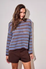 Sweater de punto con diseño de rayas horizontales en tonos azul, marrón y crema. Presenta cuello redondo, mangas largas y un corte holgado con textura acanalada.