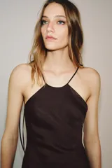 Vestido midi de Zara Woman Collection confeccionado en tejido satinado color marrón chocolate. Presenta un diseño de cuello halter con tirantes finos ajustables mediante lazada en la espalda y una caída fluida.