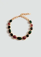 Gargantilla de eslabones dorados decorados con piedras ovaladas de resina en tonos verde, rojo y negro.