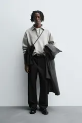 Polo de punto de corte relajado, confeccionado en mezcla de algodón, con cuello solapa, cierre frontal de cremallera y manga larga con acabados en rib.