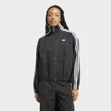 Campera Adidas Firebird AOP extragrande, de tejido denim con estampado animal print en tonos grises y negros. Presenta cuello alto, cierre frontal completo, bolsillos laterales y las clásicas tres tiras blancas de la marca en las mangas.