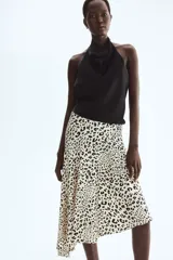 Pollera midi asimétrica de viscosa, con estampado animal print de leopardo, tiro alto y elástico oculto en la cintura. Presenta costura diagonal en las caderas y caída al bies con bajo irregular.