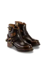 Botas cortas de cuero negro con hebillas y tachas plateadas.