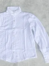 Blusa blanca de algodón con cuello alto con volados, mangas largas abullonadas y bordado calado.