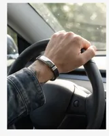 Pulsera de diseño moderno compuesta por una banda de goma negra y una placa central de acero inoxidable pulido.