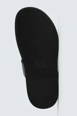 Sandalia plana negra con tiras anchas cruzadas sobre el empeine y una tira que separa el dedo gordo. Posee plantilla anatómica.