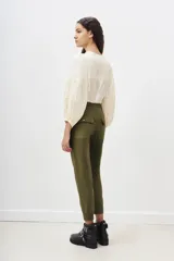 Pantalón tipo babucha de gabardina elastizada, color negro, con cintura elástica ajustable mediante cordón, puños en los tobillos, bolsillos diagonales frontales y bolsillos traseros con solapa y botón.