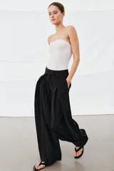 Pantalón de tiro medio de la ZW Collection, color negro, con diseño de pierna ancha (wide leg) y detalle de pliegues en la parte delantera. Cuenta con bolsillos laterales ocultos y cierre frontal con cremallera, botón y ganchos metálicos.