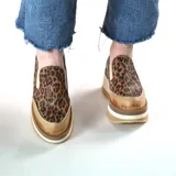 Zapatos deportivos urbanos de cuero, con diseño animal print de leopardo, elásticos laterales y suela de plataforma alta con capas en tonos marrón, blanco y tostado.