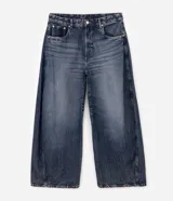 Pantalón de jean con calce barrel, caracterizado por su volumen amplio en las piernas y un sutil ajuste en la botamanga. Presenta costuras desplazadas y un lavado medio, confeccionado en algodón resistente.