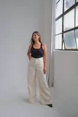 Jean de corte wide leg en color crudo, con tiro alto y costuras reforzadas en contraste. Presenta diseño de cinco bolsillos y cierre frontal con botón metálico.