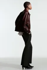 Pantalón sastrero de corte acampanado, con cierre frontal, botón oculto y corchetes. Presenta bolsillos al bies, bolsillos traseros ribeteados y pliegues marcados tanto en la parte delantera como en la trasera.