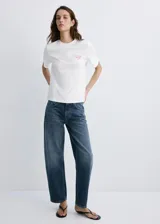 Remera blanca de manga corta y cuello redondo, confeccionada en algodón 100%. Presenta un pequeño bordado en el pecho.