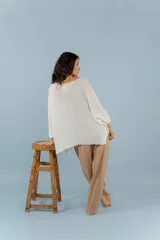 Buzo de hilo con tejido de punto fino, de corte holgado y mangas tres cuartos. Presenta un diseño versátil con cuello redondo amplio y acabado ligeramente brillante.