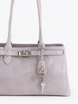 Cartera de hombro color gris, confeccionada en cuero vacuno descarne. Presenta un diseño estructurado con cierre de torniquete metálico y detalle de llavero colgante con candado y llave. Cuenta con doble asa fija.