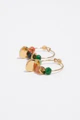 Caravanas tipo argolla dorada decoradas con cuentas de piedras de colores y un dije colgante cilíndrico con inscripciones.