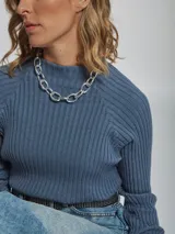 Polera de tejido rib color azul, con cuello alto y mangas largas, de corte ajustado.