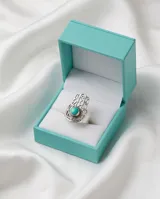 Anillo de plata 925 con diseño de mano de Fátima (Hamsa) calado y piedra turquesa central engastada.