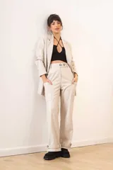 Blazer de cuero sintético color beige, con diseño de doble botonadura, solapas clásicas y bolsillos frontales con solapa.