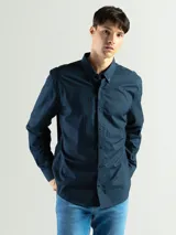 Camisa de manga larga color azul marino, confeccionada en algodón, con cuello abotonado (button-down) y un pequeño logo bordado en el pecho.