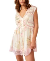 Vestido corto blanco con estampado floral en tonos pastel y detalles de encaje rosa. Tiene escote en V, botones frontales y volantes.