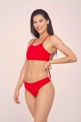 Top de bikini rojo con escote halter y tiras cruzadas en la espalda.