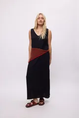 Vestido blanco sin mangas, confeccionado en algodón con textura, presenta un escote en V con detalle de trenzado en el borde y una placa metálica pequeña con logo en la espalda.