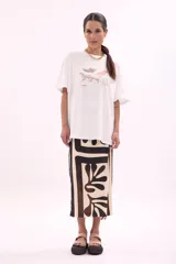 Remera blanca de manga corta, corte oversize, con estampa colorida de motivos marinos y botánicos en el frente.