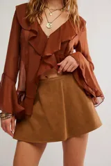 Skort corto de línea A en color marrón, confeccionado en material texturizado simil ante, de tiro medio con vuelo al frente y short interno con cintura elastizada en la espalda.