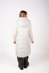 Campera larga tipo puffer color blanco, con diseño acolchado, cierre frontal y cuello alto.