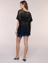 Poncho de tejido calado color beige, con mangas cortas, aberturas laterales y lazos ajustables en el cuello. Modelo Do Everything In Love.