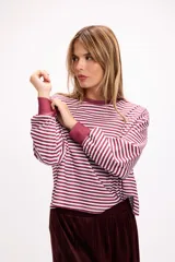 Remera de manga larga con diseño a rayas horizontales en color rojo y rosa, cuello redondo y puños elásticos.