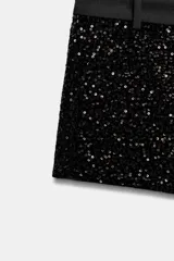 Short de tiro bajo de Zara Woman Collection, confeccionado con aplicación total de lentejuelas negras. Cuenta con pretina lisa, bolsillos delanteros y cierre frontal con cremallera y gancho metálico.