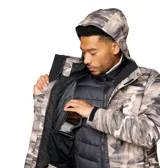 Campera técnica 3 en 1 Columbia, modelo Whirlibird V, con diseño estampado tipo camuflaje en tonos grises. Cuenta con tecnología impermeable Omni-Tech, forro termorreflectante Omni-Heat, capucha ajustable, ventilación en axilas, faldón cortaviento y múltiples bolsillos con cierre.