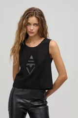 Top negro sin mangas de gamuza de cabra con apliques tribales de cuero de oveja al tono. Tiene cuello a la base y cierre metálico en la espalda.