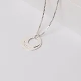 Collar de plata 925 con cadena de eslabones tipo veneciana y dije compuesto por dos aros entrelazados de superficie lisa.