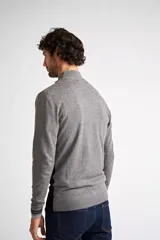 Sweater de tejido de punto con diseño color block en tonos gris, gris claro y negro. Presenta cuello levemente elevado con cierre frontal parcial, mangas largas con puños acanalados y logo bordado en el pecho.