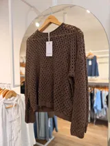 Sweater de punto calado color marrón chocolate, de corte oversize y manga larga.