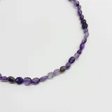 Collar elaborado con cuentas de amatista natural de formas irregulares y cierre metálico con baño de oro.