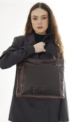 Cartera tipo tote de cuero vacuno negro con doble asa de hombro, panel superior liso y bolsillo exterior frontal con textura símil cocodrilo y costuras visibles en contraste.