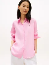 Camisa de lino puro de corte amplio color rosado, con cuello inglés, mangas largas con puños abotonados, bajo camisero y logo bordado en el pecho.