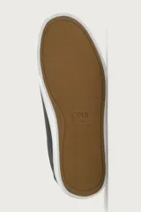 Zapatilla de estilo minimalista con cordones, confeccionada en material sintético de acabado mate. Presenta una horma redonda, forro interior en tono contrastante y suela de goma con textura ligera.
